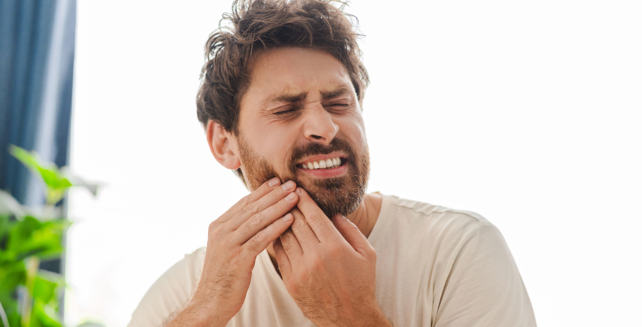 Man experiencing dental pain and seeking an oral surgery evaluation