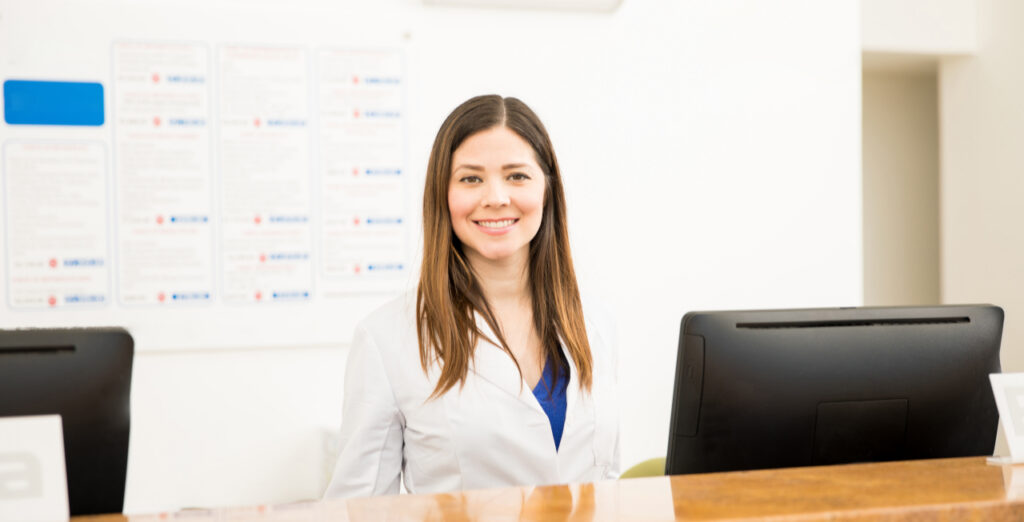 Dental Receptionist Lindsay Beckring smiling at her desk