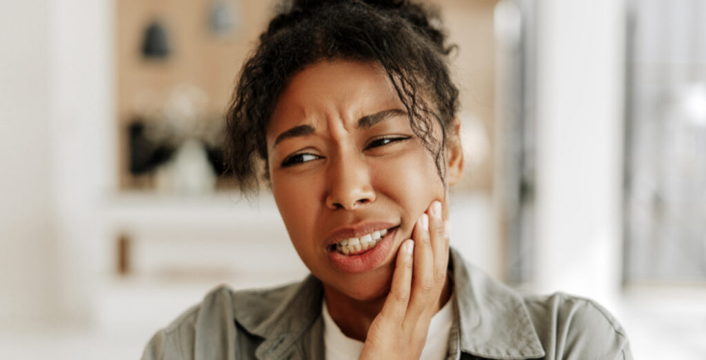 Woman experiencing tooth pain that may require an oral surgery evaluation